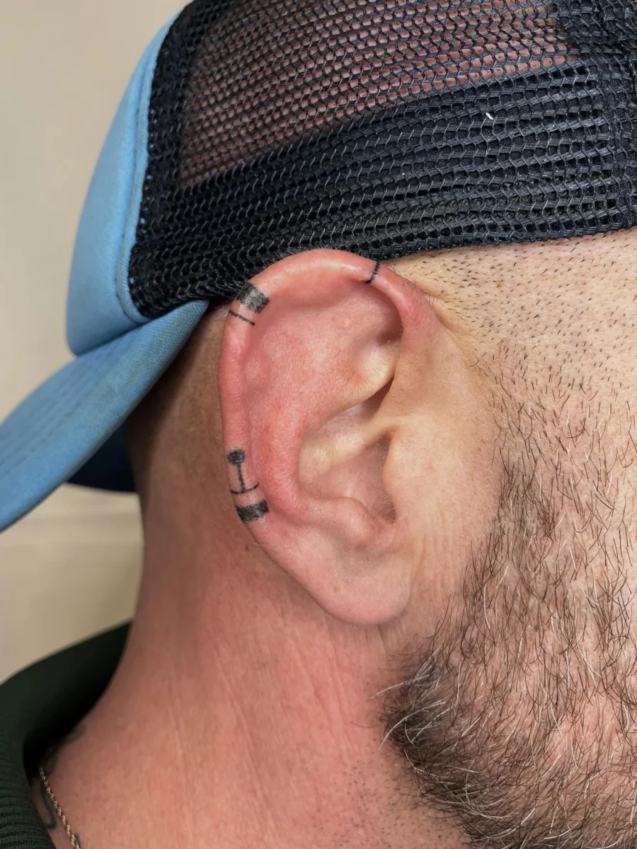 Tatouage handpoke ornemental autour de l’oreille, réalisé par Flori Green