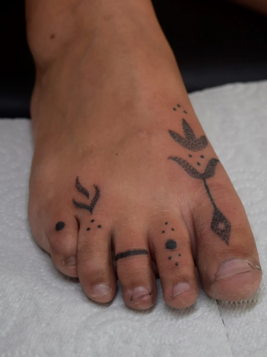 Tatouage handpoke ornemental sur le pied ou la cheville, réalisé par Flori Green