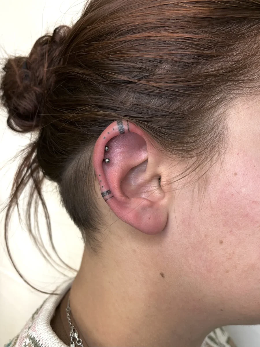 Tatouage handpoke ornemental autour de l’oreille, réalisé par Flori Green