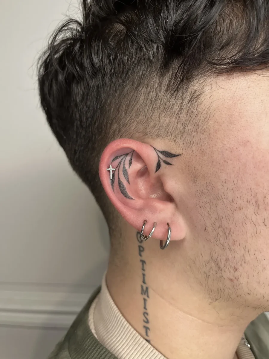 Tatouage handpoke ornemental autour de l’oreille, réalisé par Flori Green