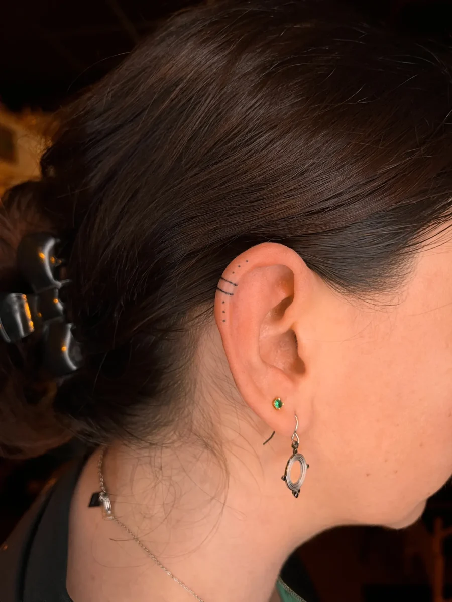Tatouage handpoke ornemental autour de l’oreille, réalisé par Flori Green