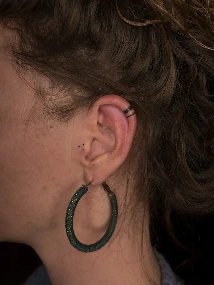 Tatouage handpoke ornemental autour de l’oreille, réalisé par Flori Green