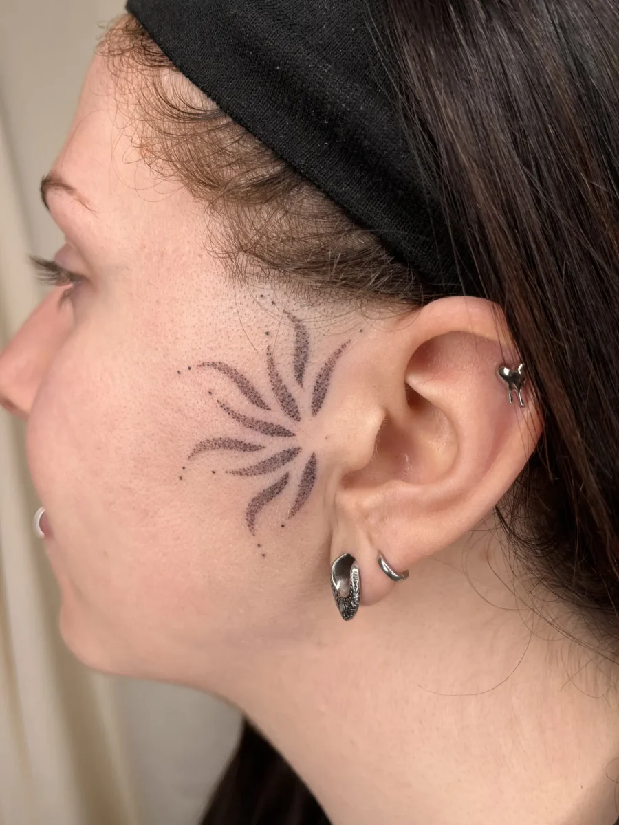 Tatouage handpoke ornemental sur le visage ou la tête, réalisé par Flori Green