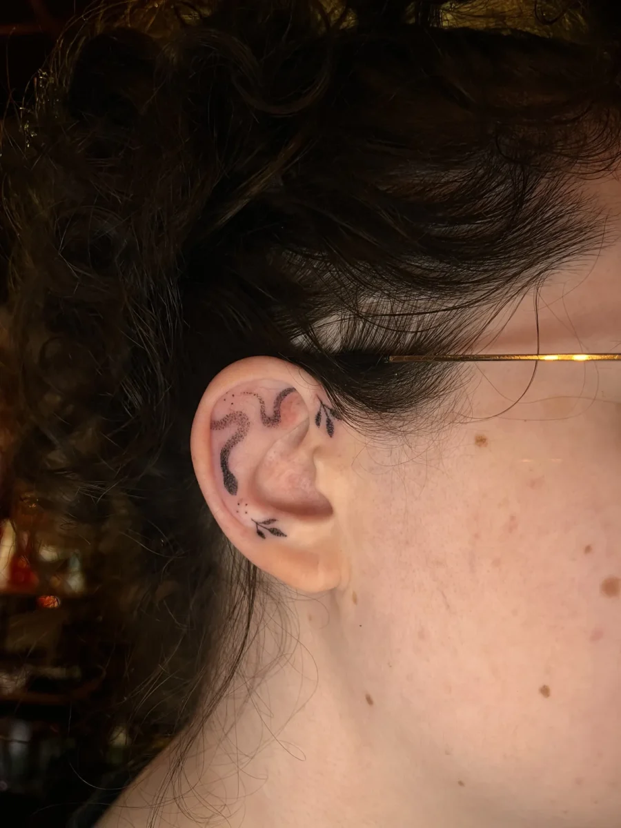 Tatouage handpoke ornemental autour de l’oreille, réalisé par Flori Green