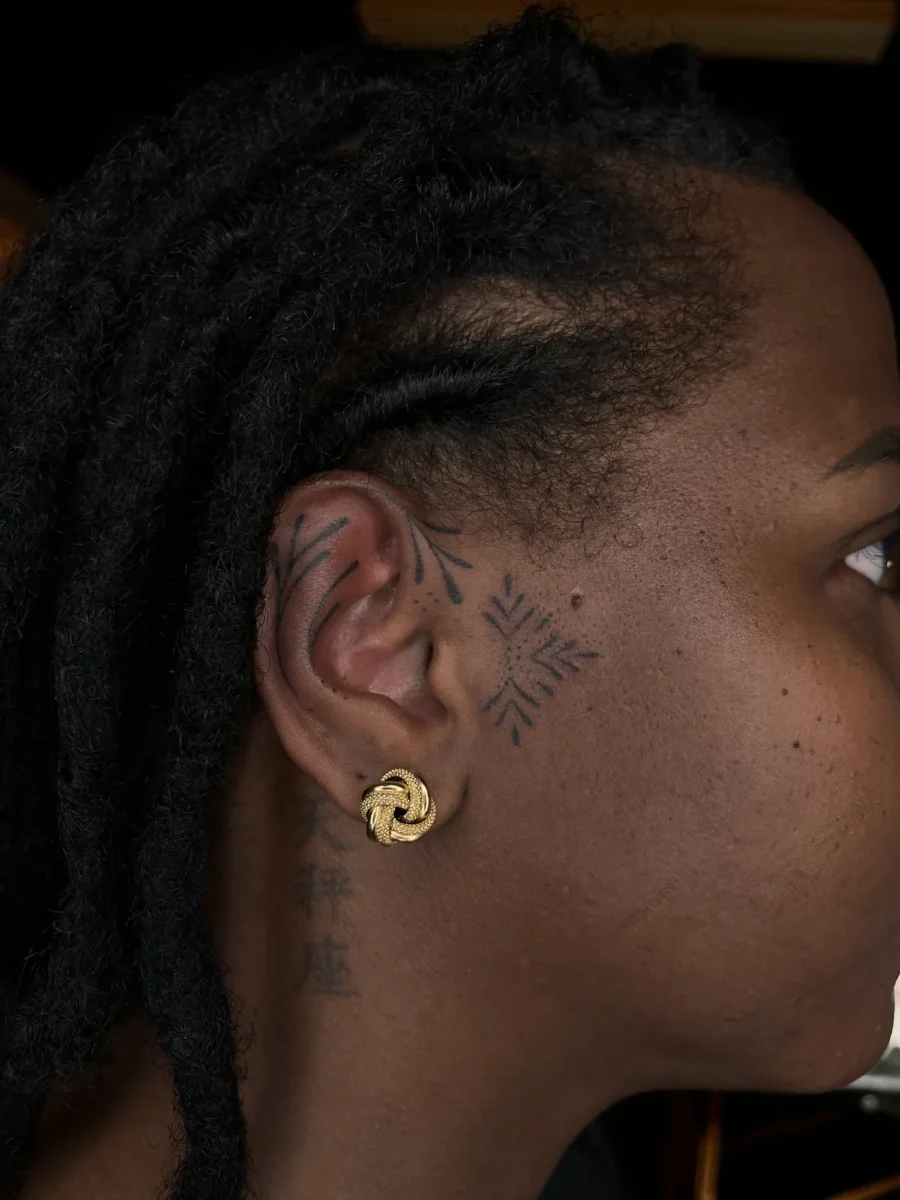 Tatouage handpoke ornemental sur le visage ou la tête, réalisé par Flori Green