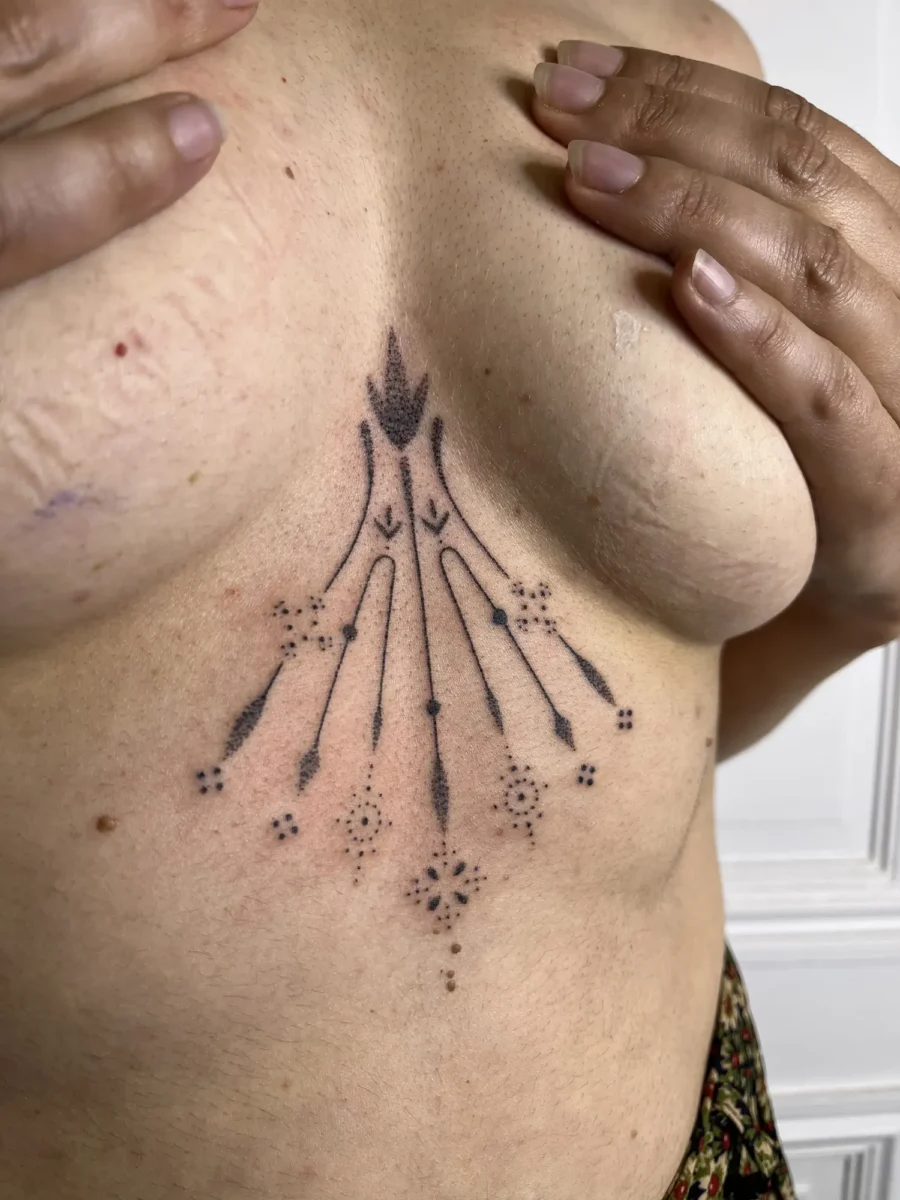 Tatouage handpoke ornemental sur la poitrine ou le torse, réalisé par Flori Green