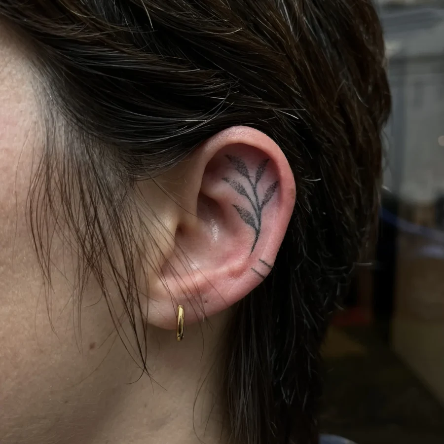 Tatouage handpoke ornemental autour de l’oreille, réalisé par Flori Green